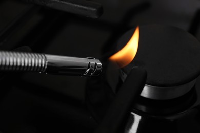 Photo of Lighting stove with gas lighter, closeup view