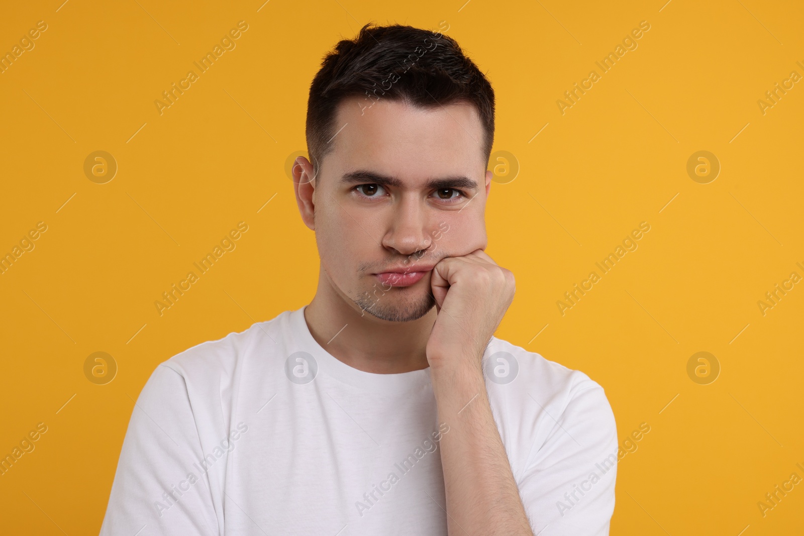 Photo of Portrait of resentful man on orange background