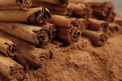 Photo of Cinnamon sticks and powder as background, closeup