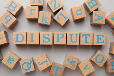 Cubes with word Dispute on light grey background, flat lay