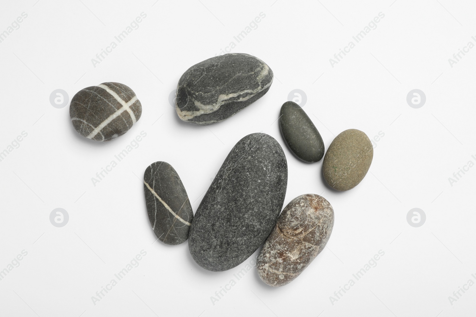 Photo of Many different stones on white background, top view