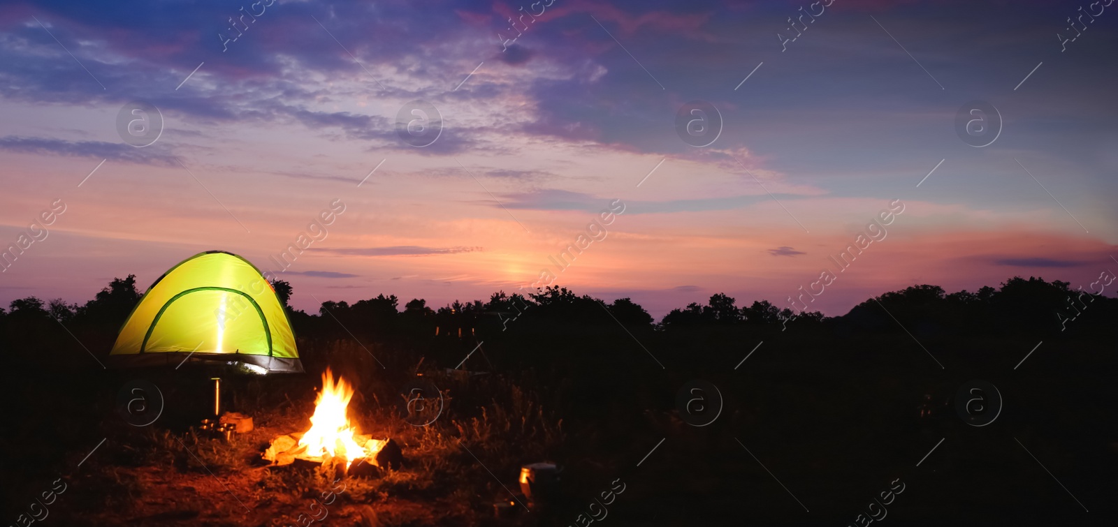 Image of Camping tent near small bonfire in twilight. Banner design