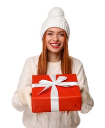 Young woman in hat and sweater with Christmas gift on white background