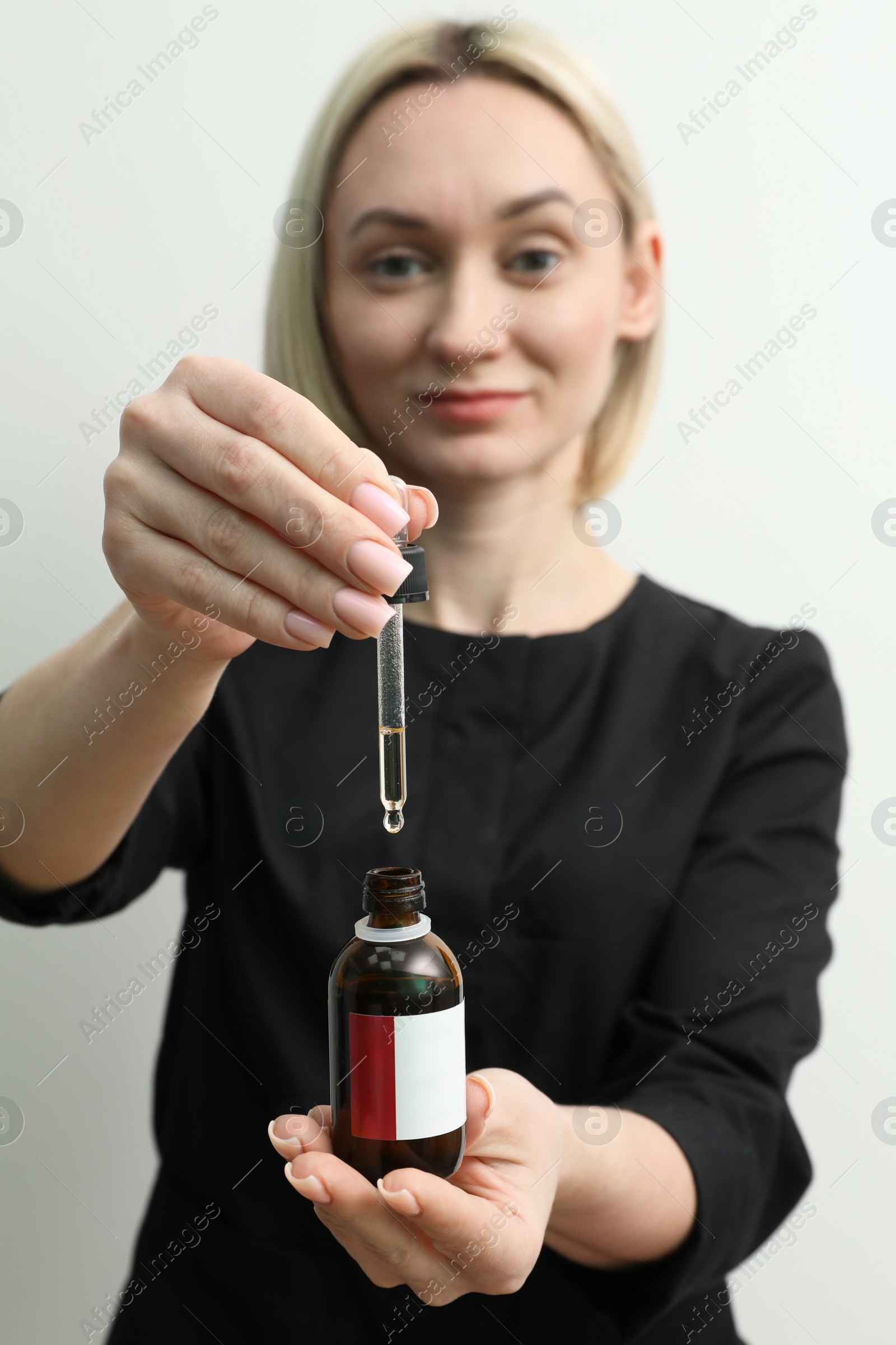 Photo of Cosmetologist with peeling product on white background, selective focus