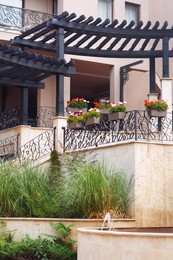 Exterior of building with balconies decorated with beautiful flowers and plants