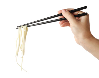 Woman holding chopsticks with tasty cooked rice noodles on white background, closeup