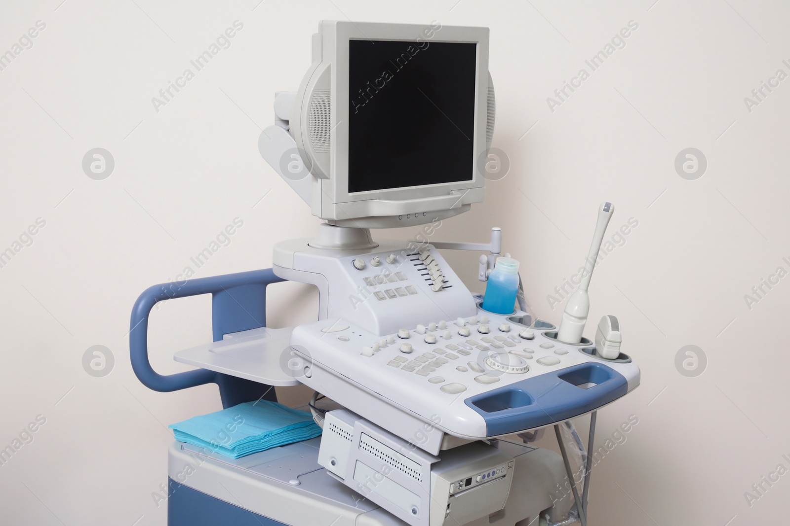 Photo of Ultrasound machine near white wall. Medical equipment