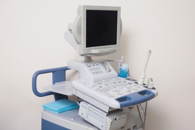 Ultrasound machine near white wall. Medical equipment