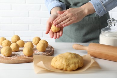 Photo of Shortcrust pastry. Woman making dough ball at white wooden table, closeup
