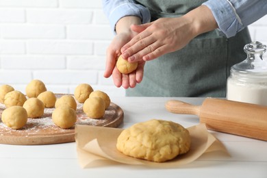 Shortcrust pastry. Woman making dough ball at white wooden table, closeup