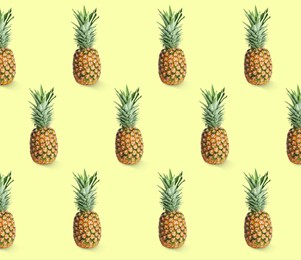 Image of Delicious ripe pineapples on yellow background. Exotic fruits