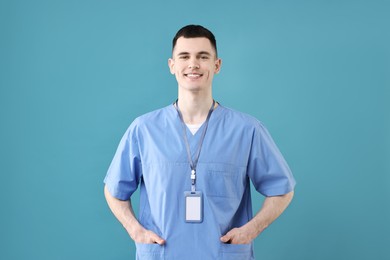 Portrait of smiling medical assistant on light blue background