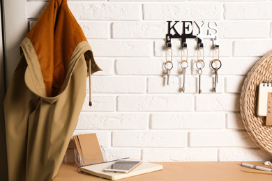 Metal key holder on white brick wall indoors