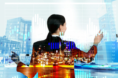 Multiple exposure of young businesswoman, graph and night cityscape 