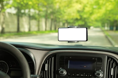 Photo of Car holder with modern mobile phone on windshield of automobile. Mockup for design