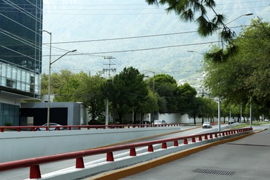 Photo of Modern road with cars in city near mountains
