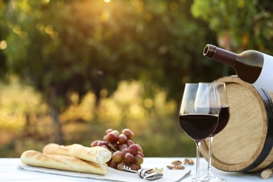 Photo of Composition with wine and snacks on white wooden table outdoors