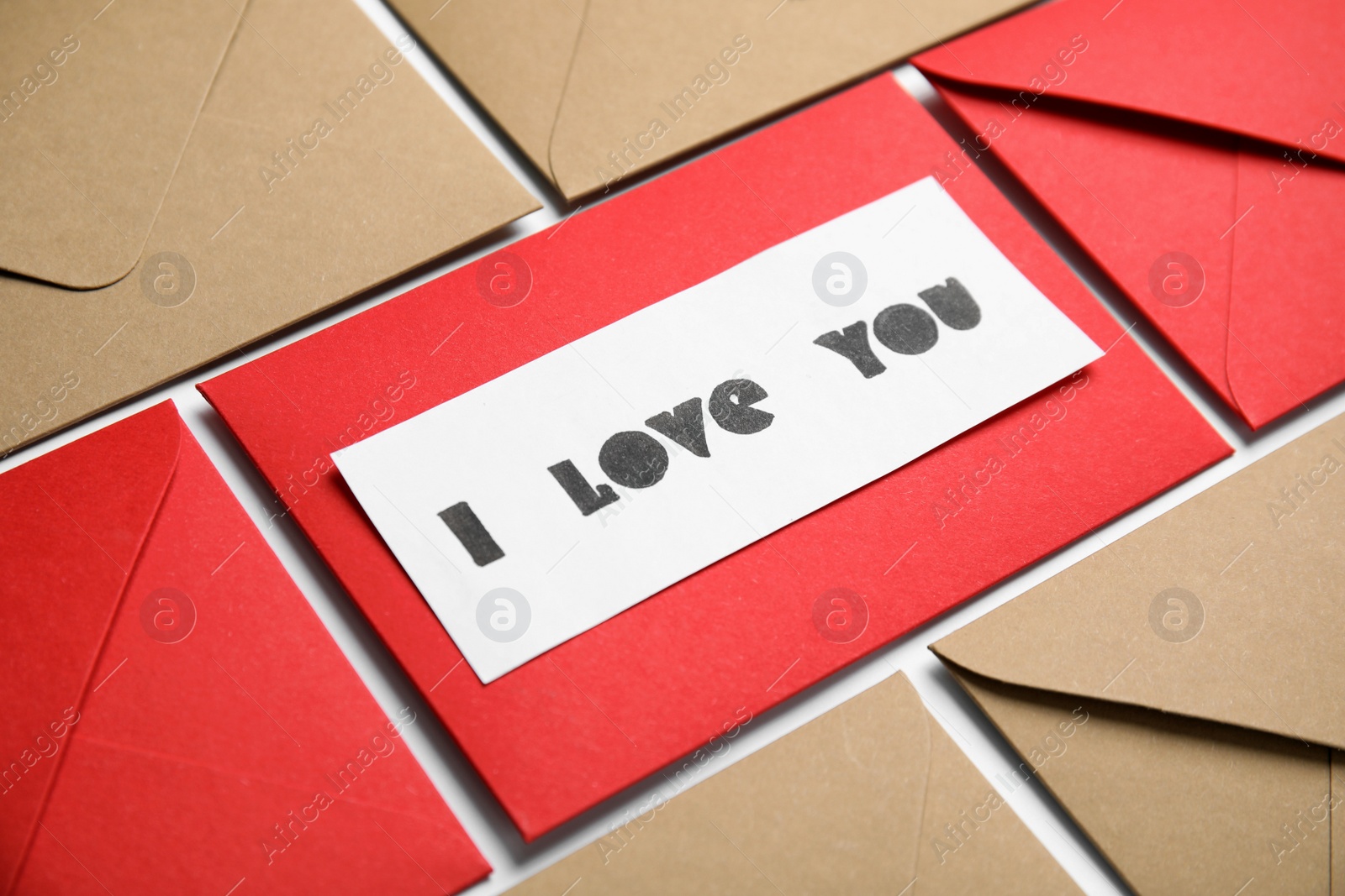 Photo of Card with phrase I Love You and envelopes on white background, closeup