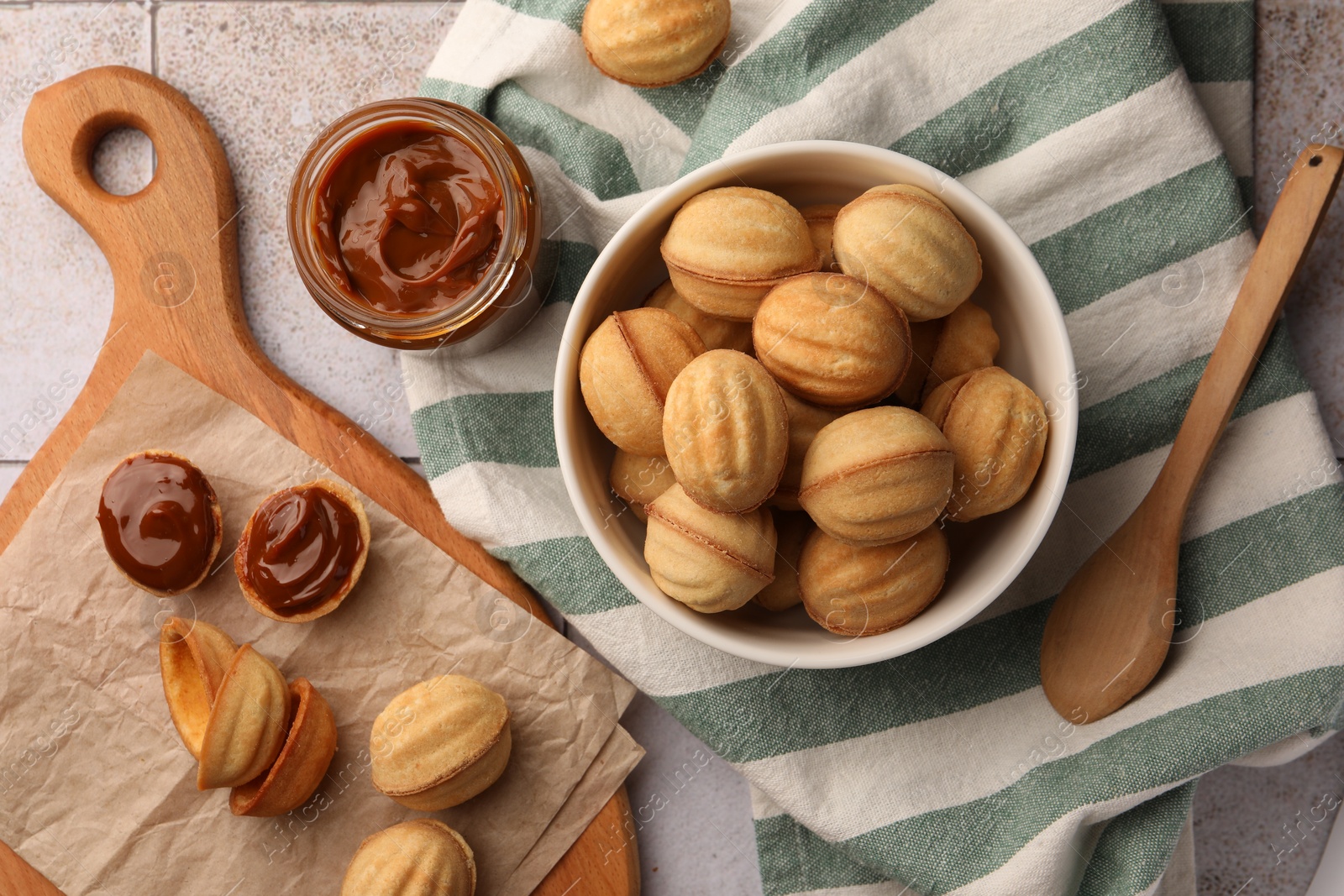 Photo of Delicious nut shaped cookies with boiled condensed milk on table, flat lay