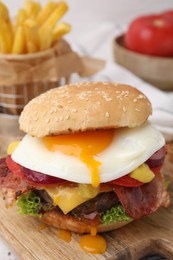 Photo of Delicious burger with fried egg on table, closeup