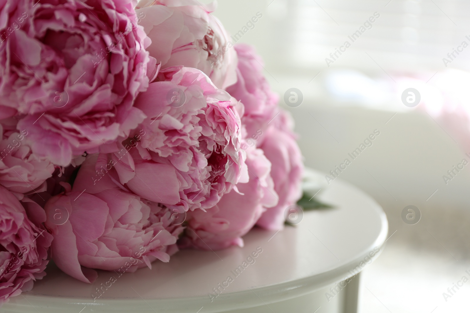 Photo of Bunch of beautiful peonies on table indoors, closeup