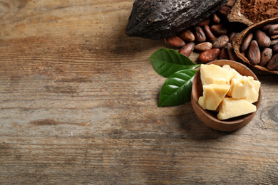 Photo of Composition with organic cocoa butter on wooden table, above view. Space for text