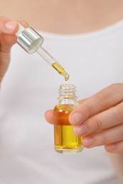 Woman with bottle of essential oil, closeup