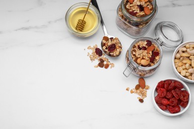 Tasty granola served with nuts and dry fruits on white marble table, flat lay. Space for text