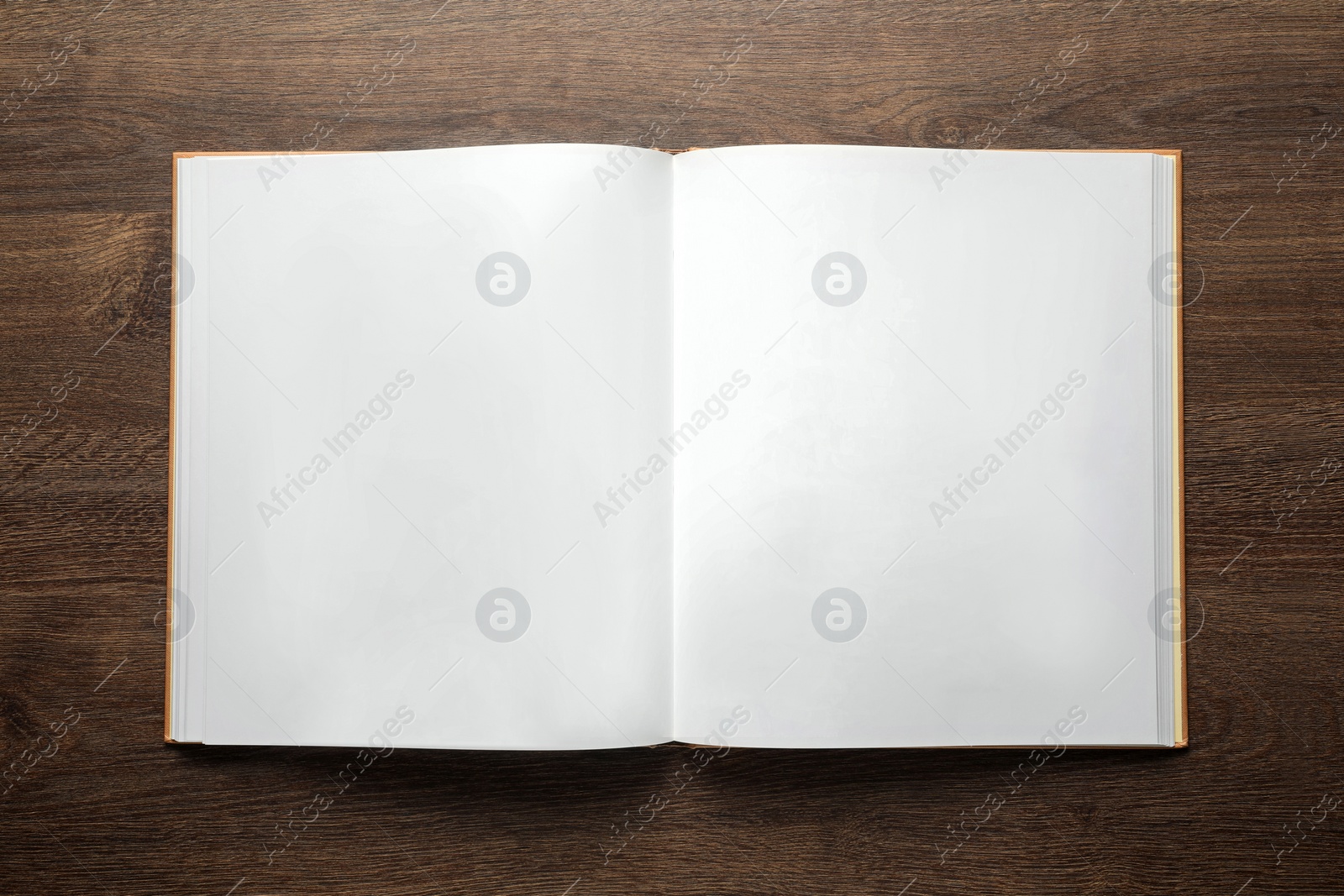 Photo of Open book on wooden table, top view