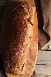 Photo of Freshly baked sourdough bread on wooden table, top view