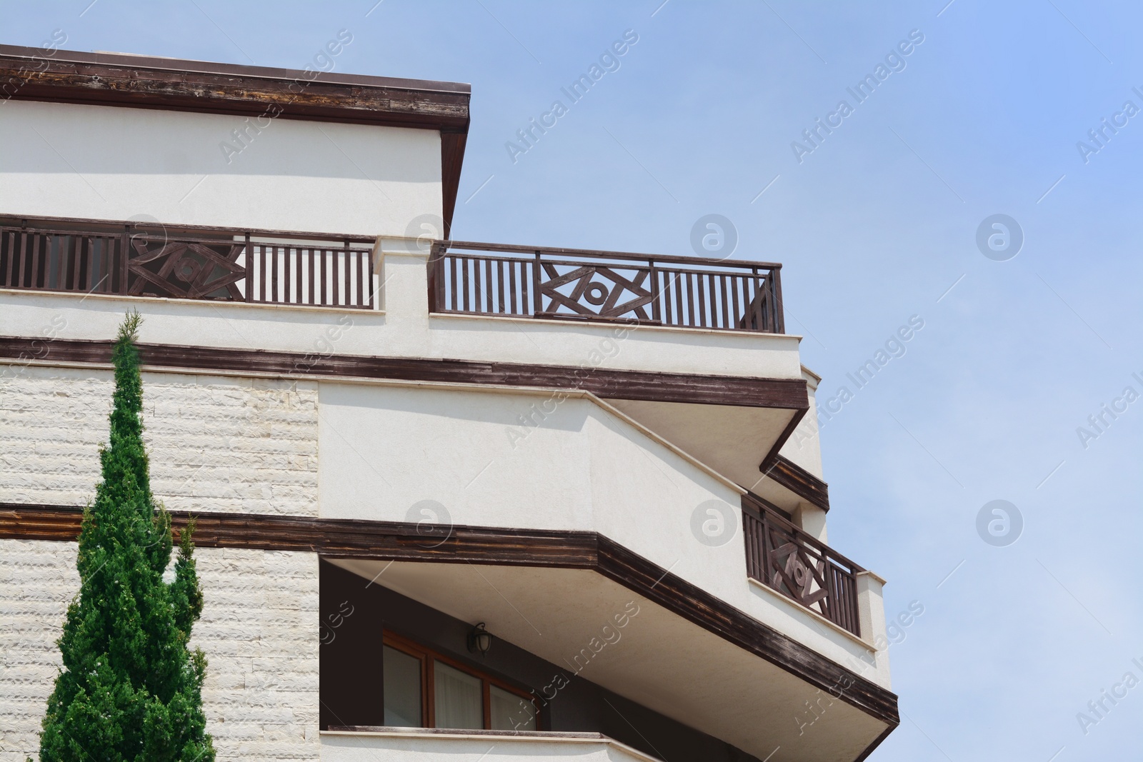 Photo of Exterior of residential building with balconies against blue sky, low angle view