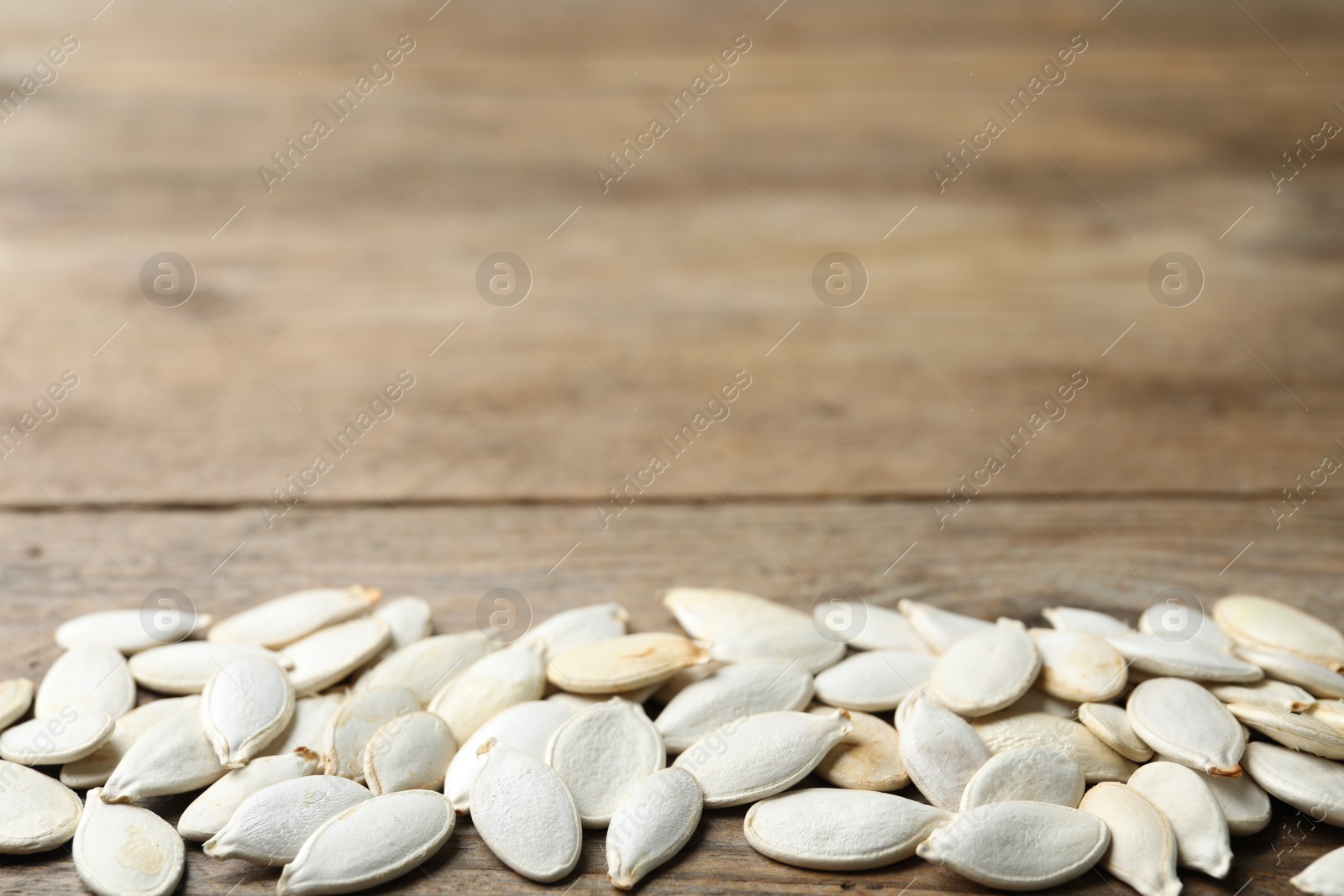 Photo of Raw pumpkin seeds on wooden background, space for text. Vegetable planting