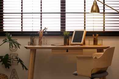 Photo of Stylish workplace with modern tablet on table at window. Ideas for interior design