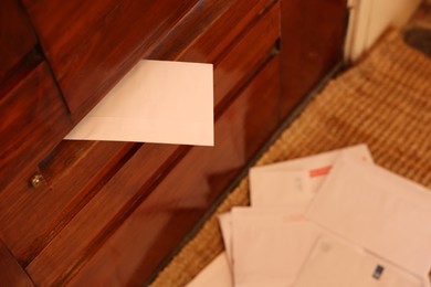 Photo of Mail slot with envelope in wooden door indoors, closeup. Space for text
