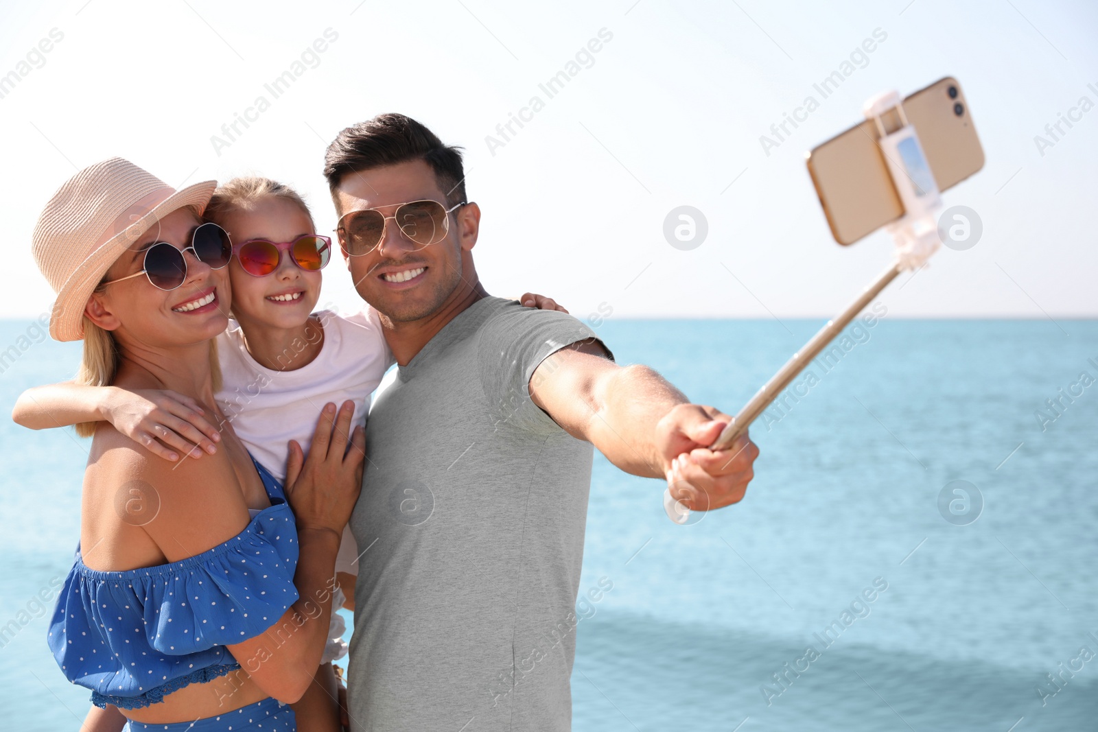 Photo of Happy family taking selfie at beach on sunny day