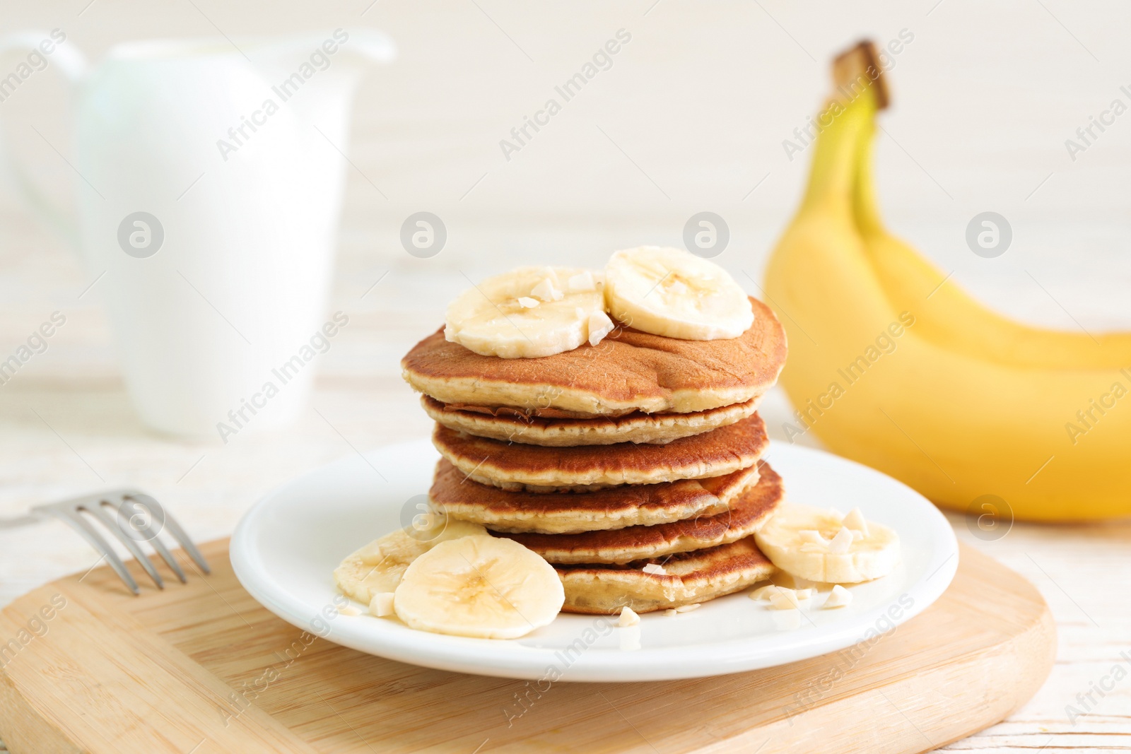 Photo of Plate of banana pancakes served on white table