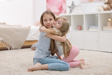 Photo of Cute little sisters spending time together at home