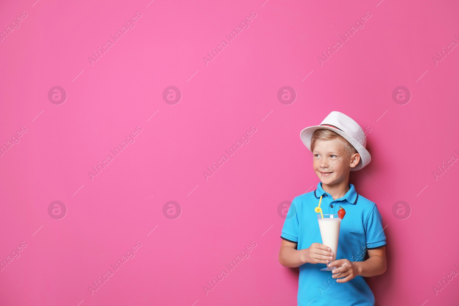 Photo of Little boy with glass of milk shake on color background