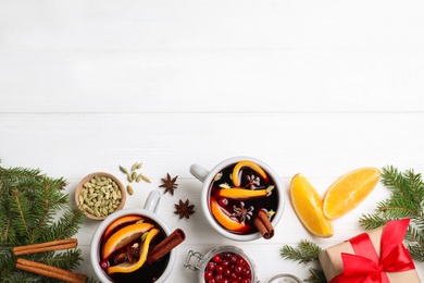 Flat lay composition with aromatic mulled wine on white wooden table. Space for text