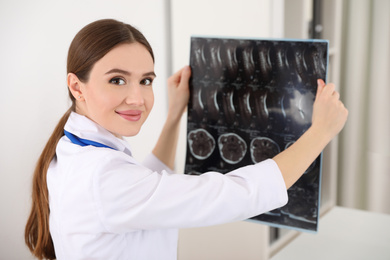 Professional orthopedist examining X-ray picture in her office