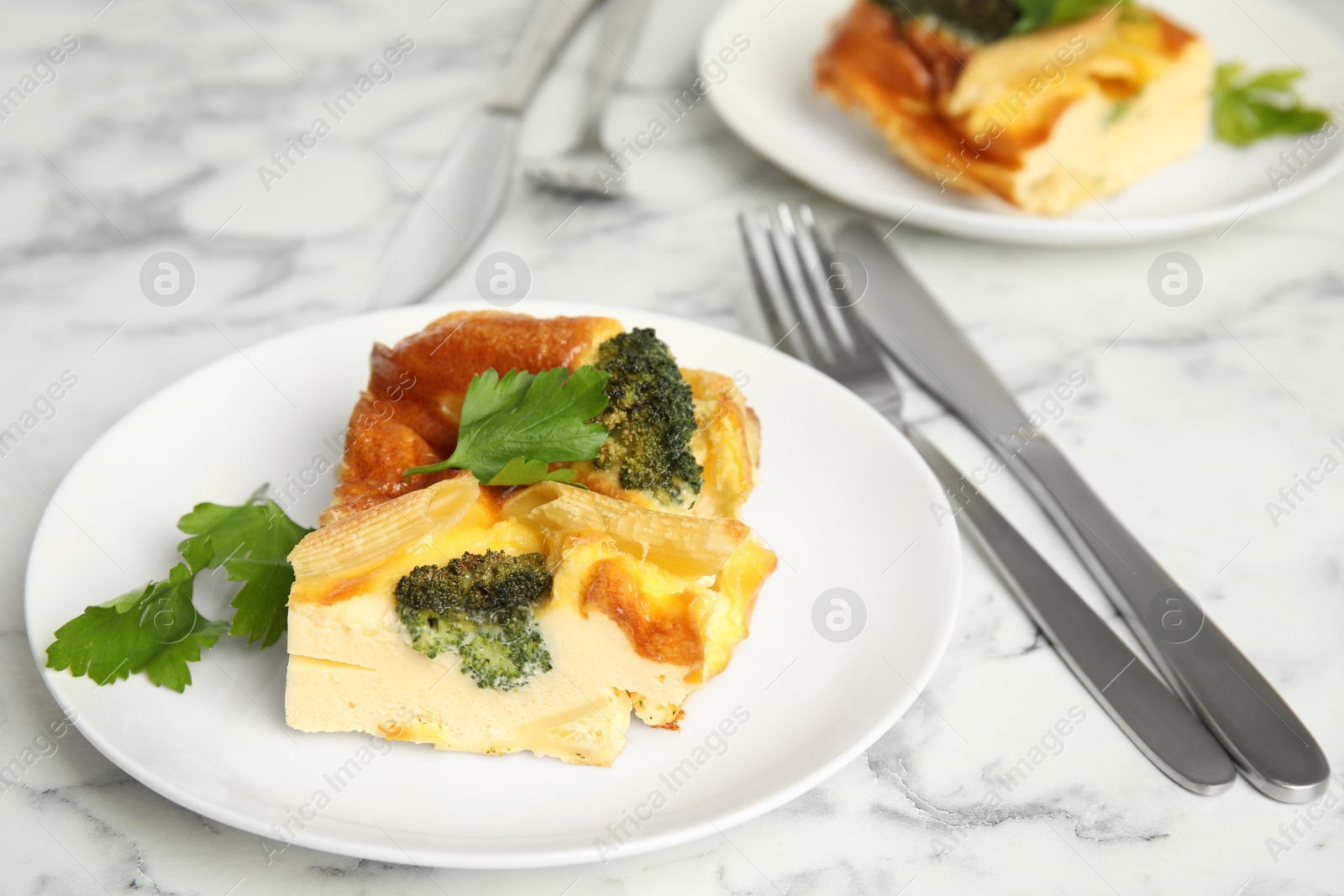 Photo of Tasty broccoli casserole served on white marble table