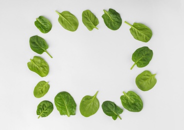 Frame made of spinach leaves on white background, top view. Space for text