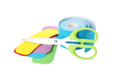 Photo of Scissors, bright kinesio tape roll and pieces on white background