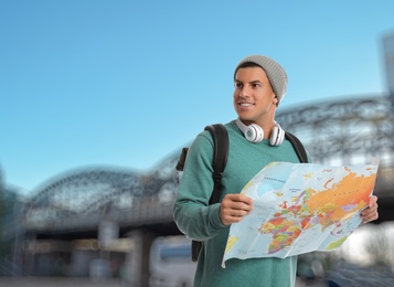 Happy traveler with map in foreign city. Vacation trip