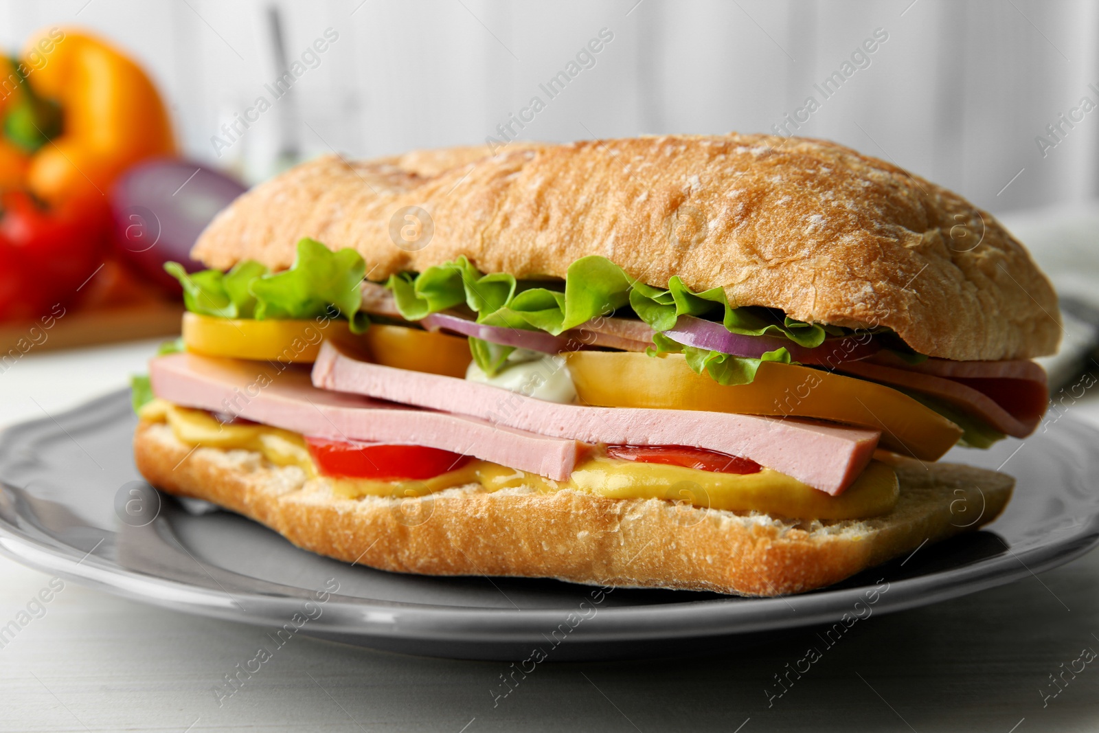 Photo of Tasty sandwich with boiled sausage, cheese and vegetables on white wooden table, closeup