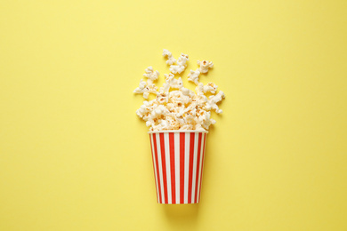 Photo of Delicious popcorn on yellow background, top view