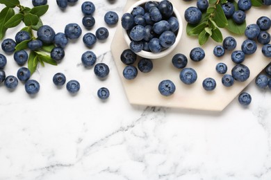 Photo of Tasty fresh blueberries on white marble table, flat lay. Space for text