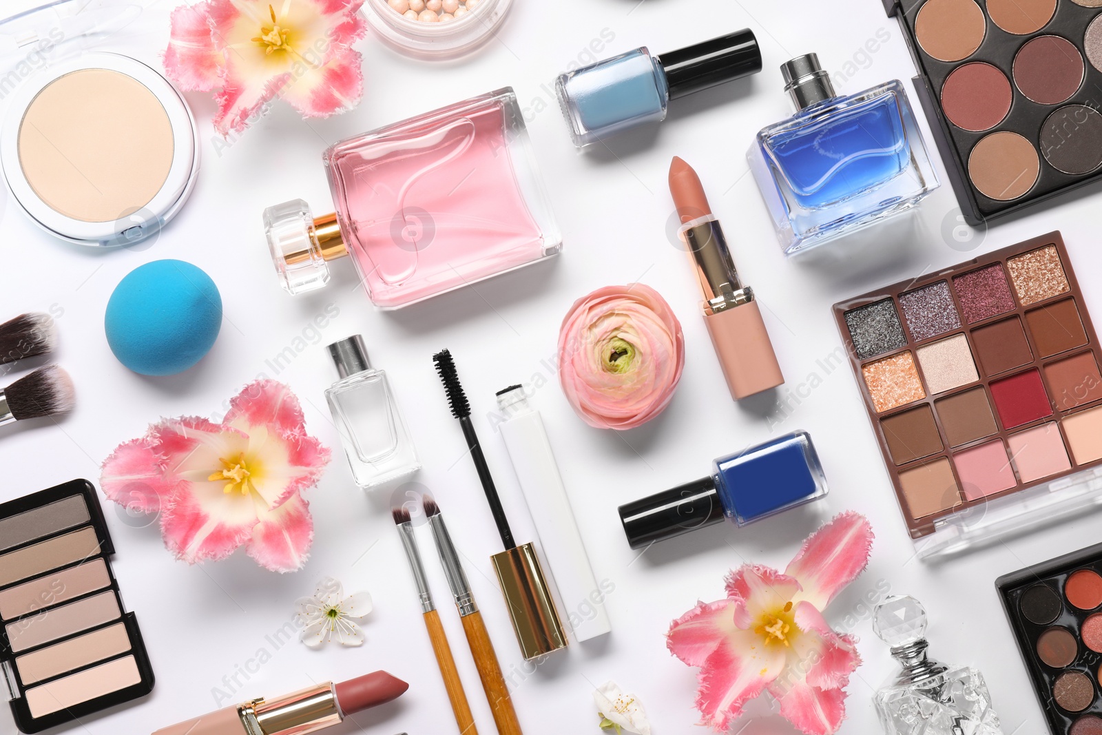 Photo of Flat lay composition with different makeup products and beautiful spring flowers on white background