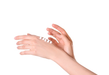 Photo of Young woman applying cream onto her hands on white background, closeup