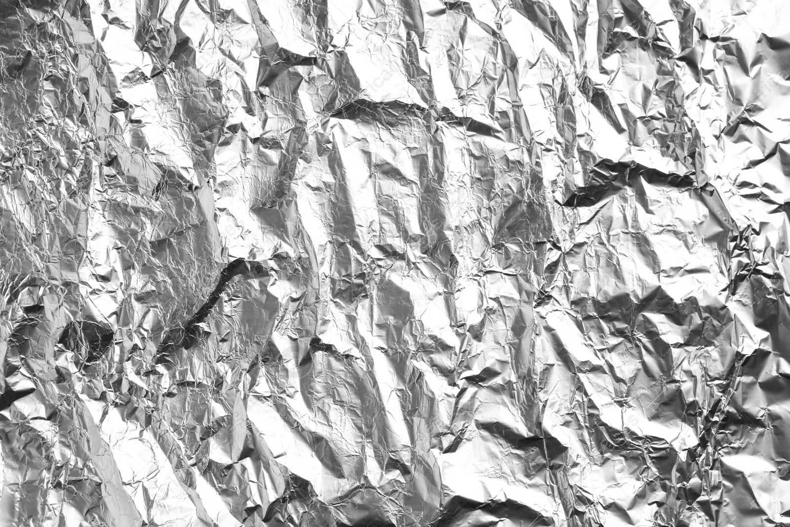 Photo of Crumpled silver foil as background, closeup view